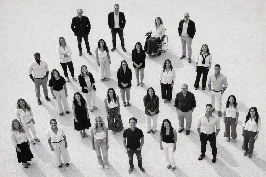 Foto de grupo del equipo de profesionales de CIDON posando sonrientes frente a una pared blanca con el nombre de la empresa.